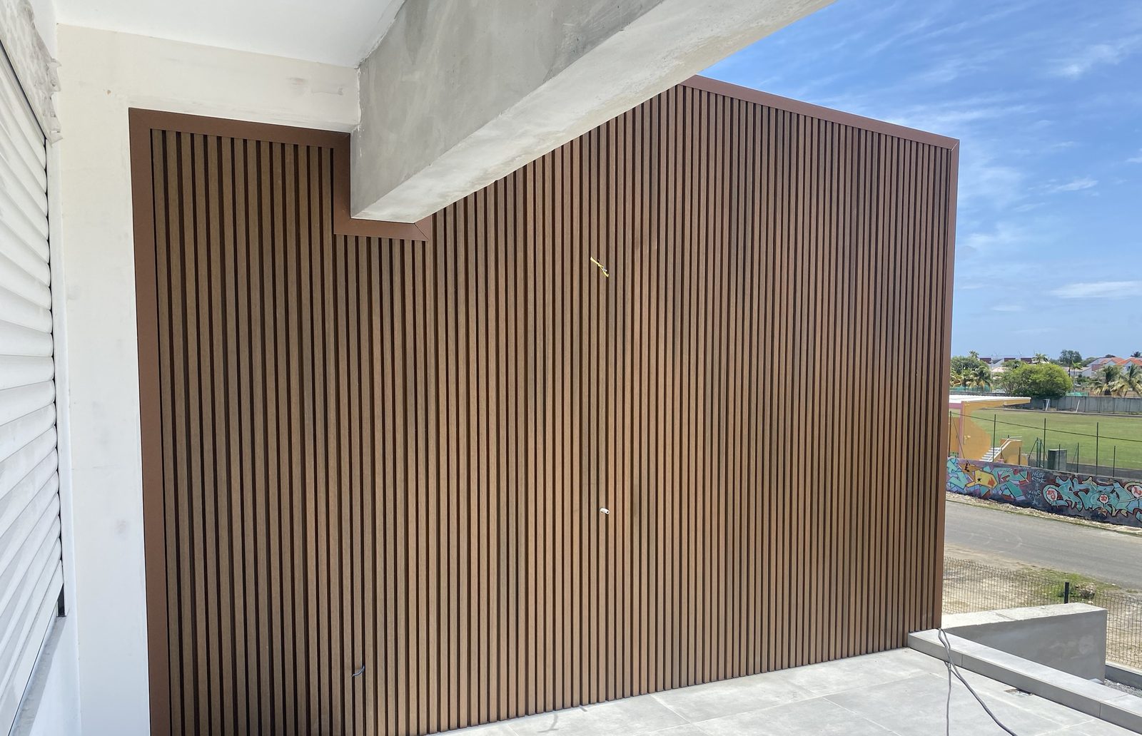 Mur de terrasse en bardage composite à lames verticales